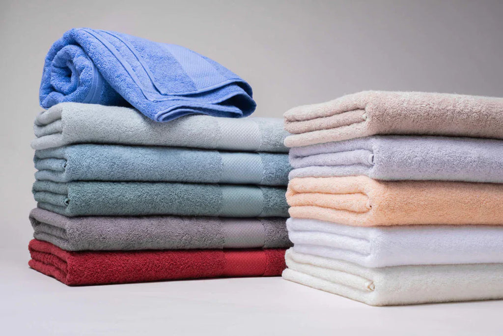 Stack of soft luxury and budget bath towels in neutral tones.