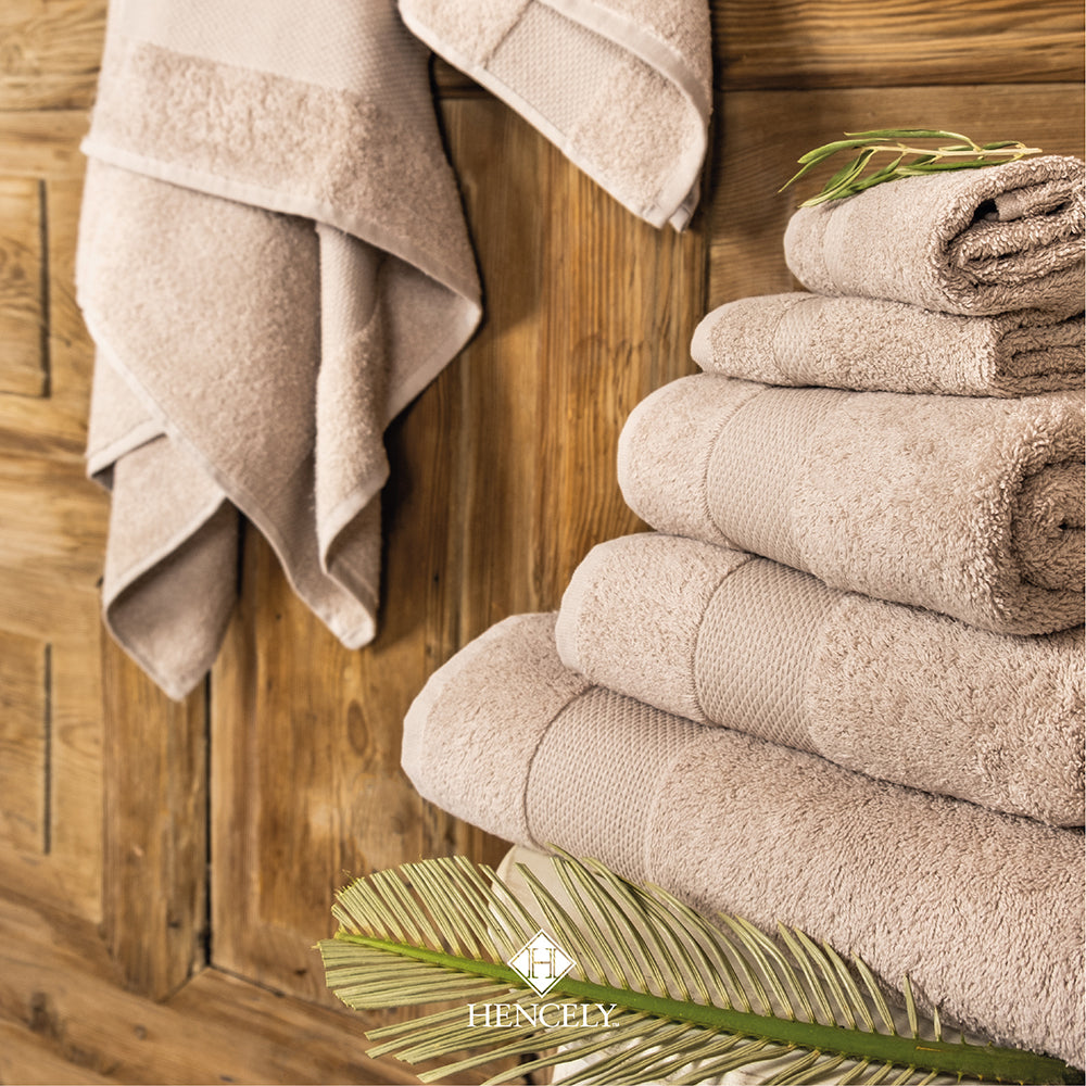 Beige Turkish cotton bath sheet with soft absorbent terry texture, rolled in a spiral to highlight plush thickness