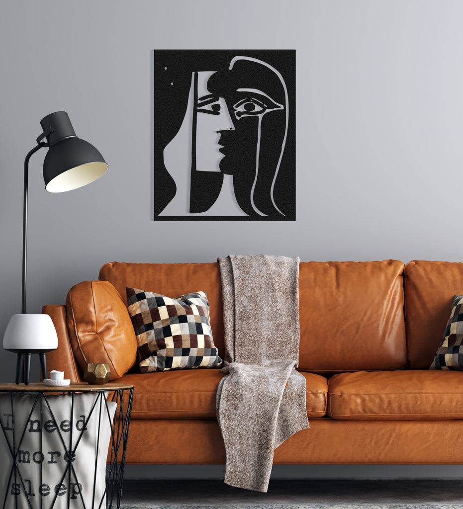 Picasso-style abstract face metal panel displayed in a minimalist room interior.