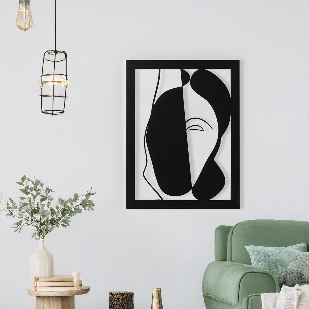 Abstract face metal wall art in black displayed in a modern living room