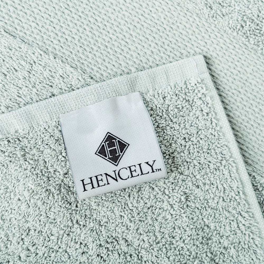 Close-up of Hencely brand label on a light green Turkish cotton bath sheet, highlighting the towel’s soft terry texture and premium stitching.