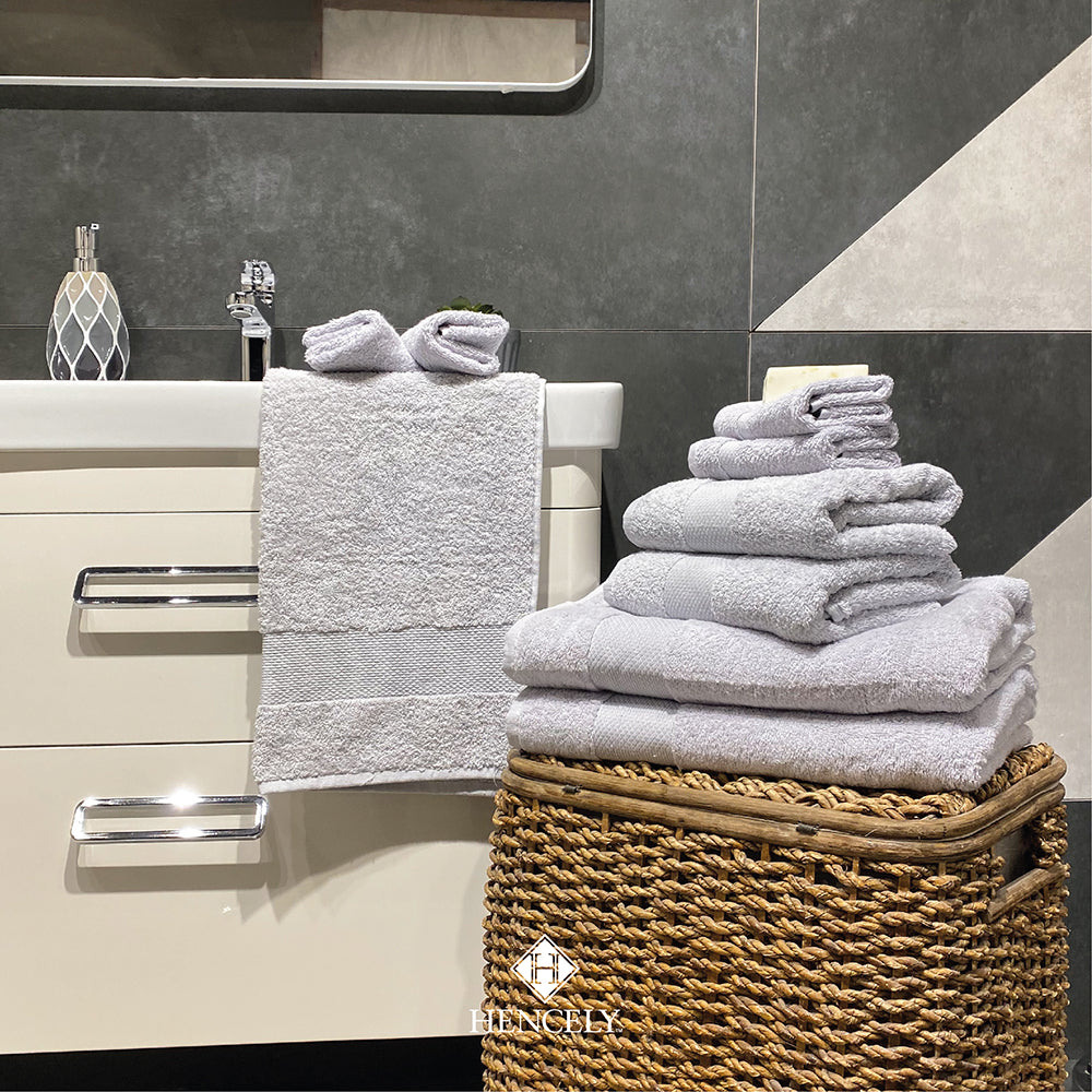 Silver cotton bath sheet set displayed in a modern bathroom with stacked and hanging towels, styled for a luxury spa look.