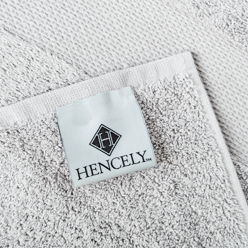 Close-up of Hencely branded label on a silver cotton bath sheet, showing premium quality and fine stitching.