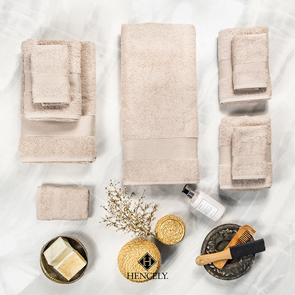 Hencely beige bath sheet set displayed on marble background with accessories, Turkish cotton towels in multiple sizes.