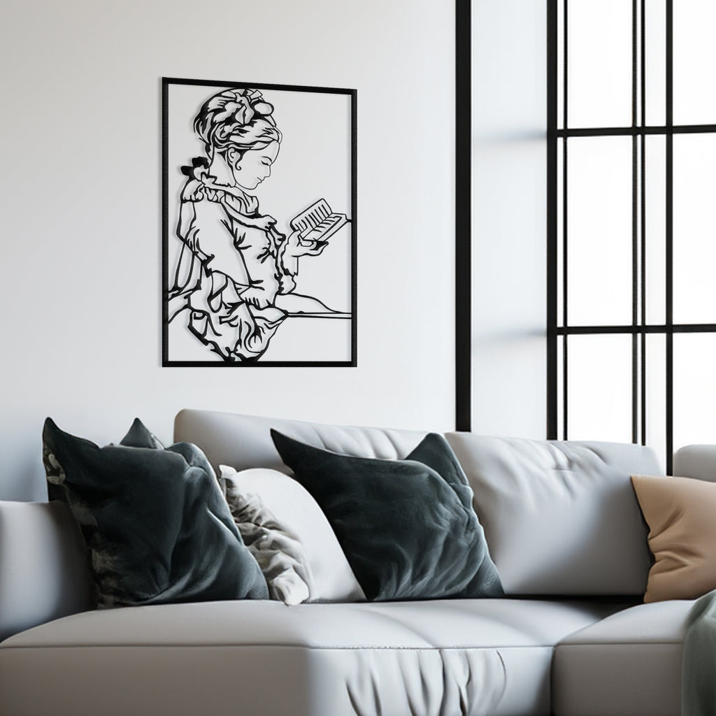Black metal wall art of woman reading displayed in study room.