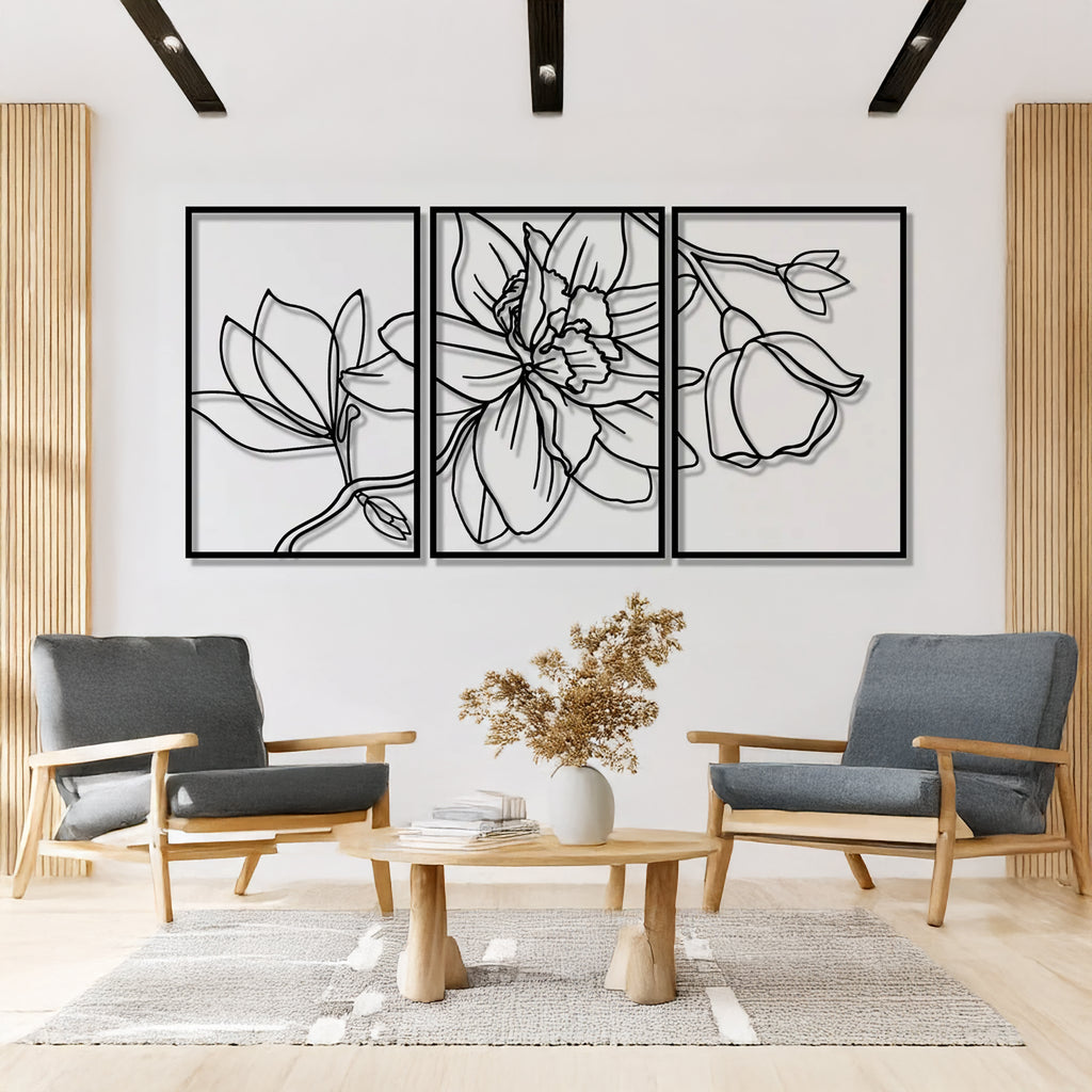 Elegant floral metal wall art set with three black botanical panels mounted on white wall in modern interior