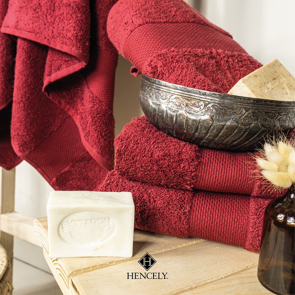 Burgundy Hencely bath sheets stacked with natural soap and decorative silver bowl for a spa-inspired look