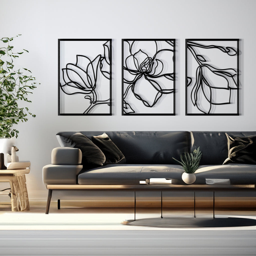 Minimalist black botanical metal wall panels displayed above couch.