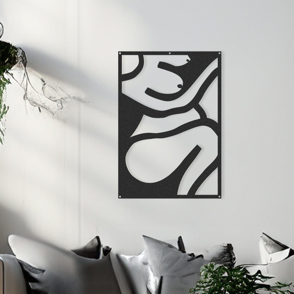 Modern black metal wall panel with abstract female form in a styled living room.