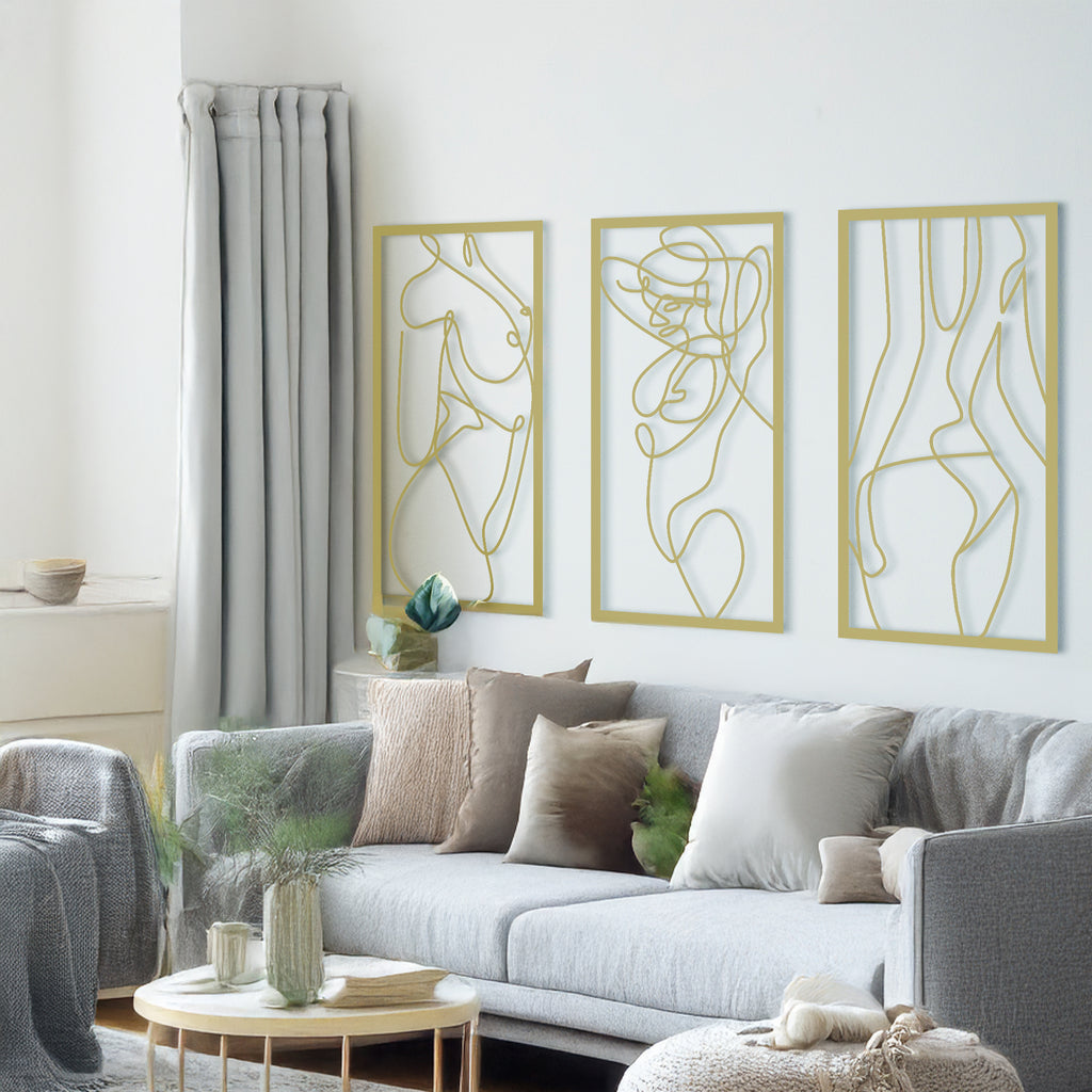 Living room with Nude Woman Gold Metal Wall Art set of 3 panels above a sofa