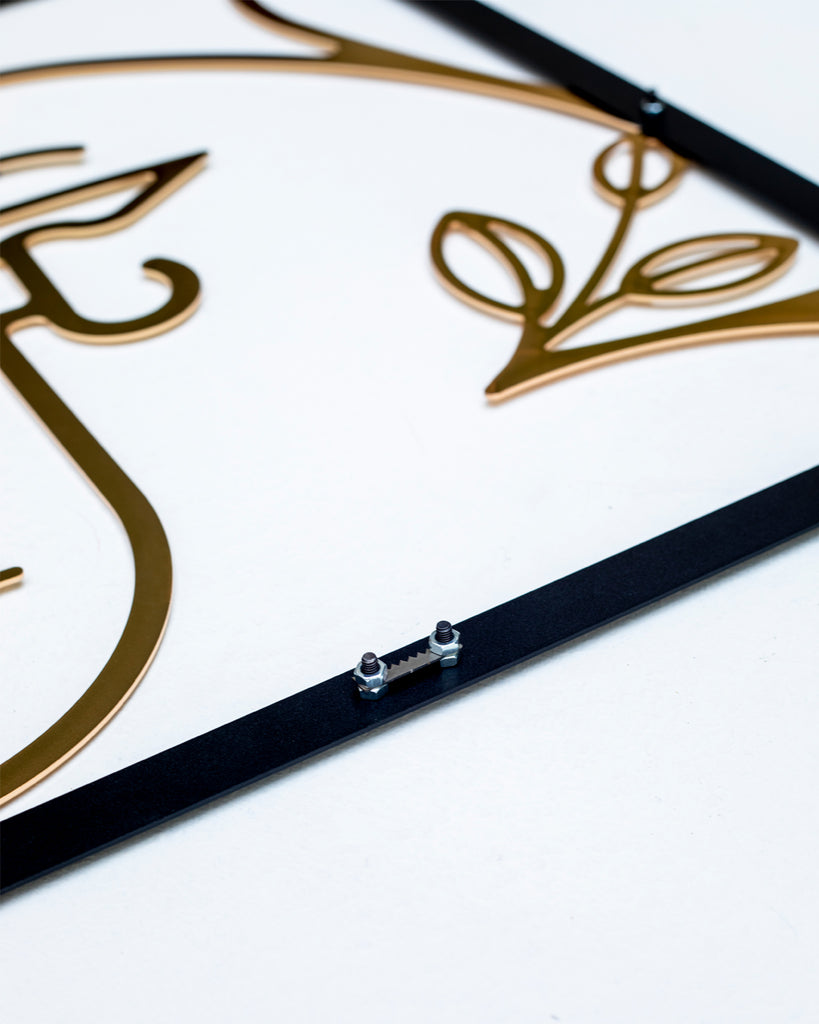 Close-up view of gold line art metal wall decor showing the female silhouette design with black steel frame and hanging hardware detail.